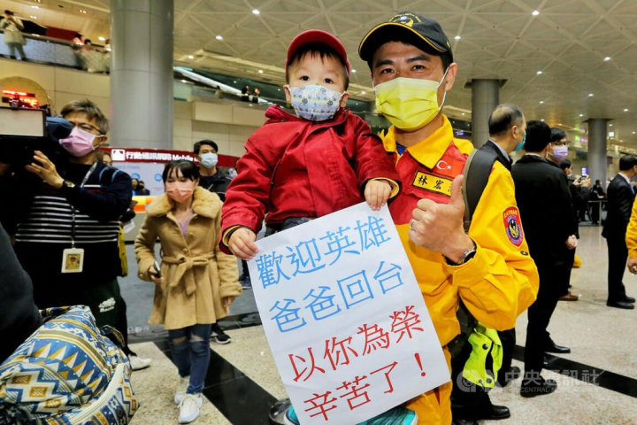 A member of the Taiwan search and rescue team reunites with his son at Taoyuan International Airport. CNA photo