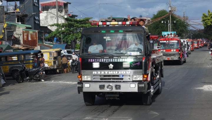 菲華義勇消防隊的救災車輛開警示燈及鳴笛經過馬尼拉市人口密度最高的湯都區