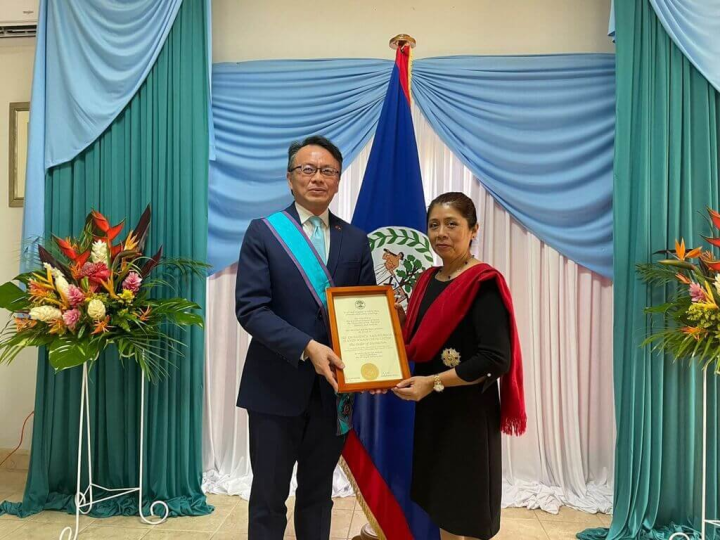 即將離任的駐貝里斯大使錢冠州（左）10日於總督府接受貝里斯總督察芙拉（右）頒贈「卓越勳章」。（駐貝里斯大使館提供）