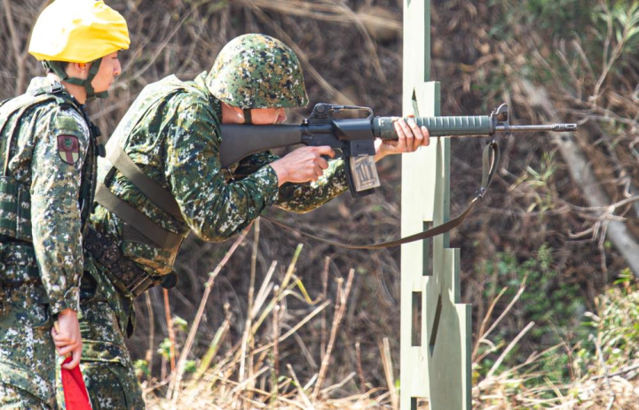 訓員於障礙板後方依序採臥姿、跪姿、立姿實施射擊。