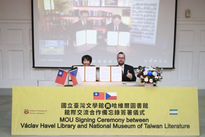哈維爾圖書館館長麥可．贊托夫斯基（Michael_Žantovský）（螢幕右）及臺文館館長林巾力（前排左）簽署象徵兩館友好之備忘錄