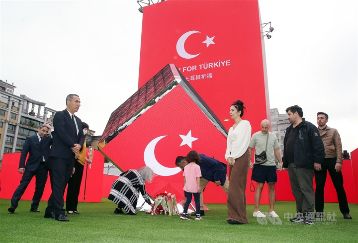Muhammed Berdibek (front, left), representative of the Turkish Trade Office in Taipei, and Turkish people in Taiwan, visit a maze made of LED panels, which began displaying "Pray for Türkiye" Tuesday evening. CNA photo Feb. 8, 2023