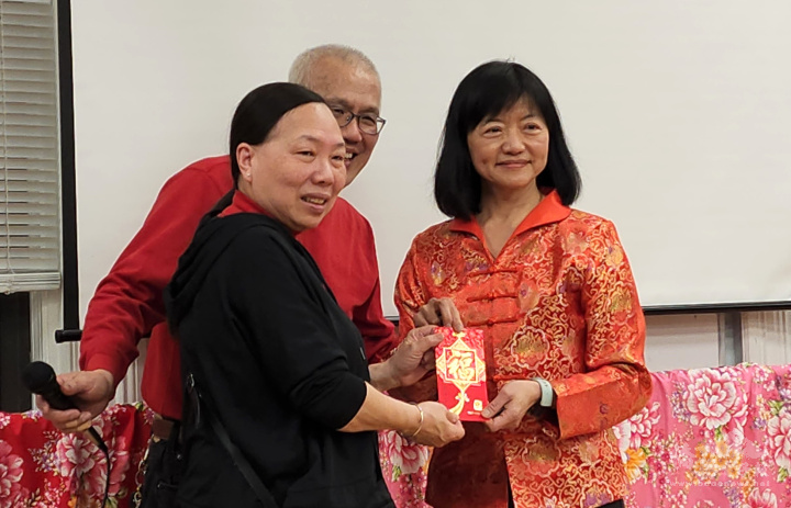 美洲臺灣客家聯合總會總會長宋玉琴發放紅包給抽獎得主余媚鳳