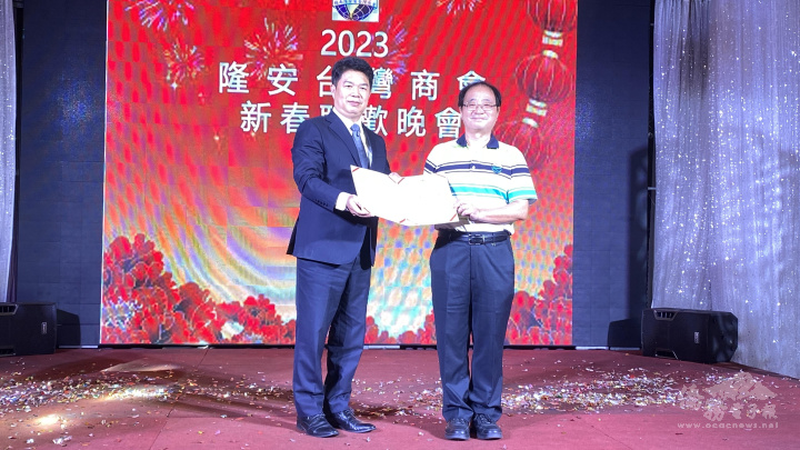 韓國耀讚揚滿任會長許聰明年來對隆安分會貢獻，代表僑委會委員長頒贈感謝狀