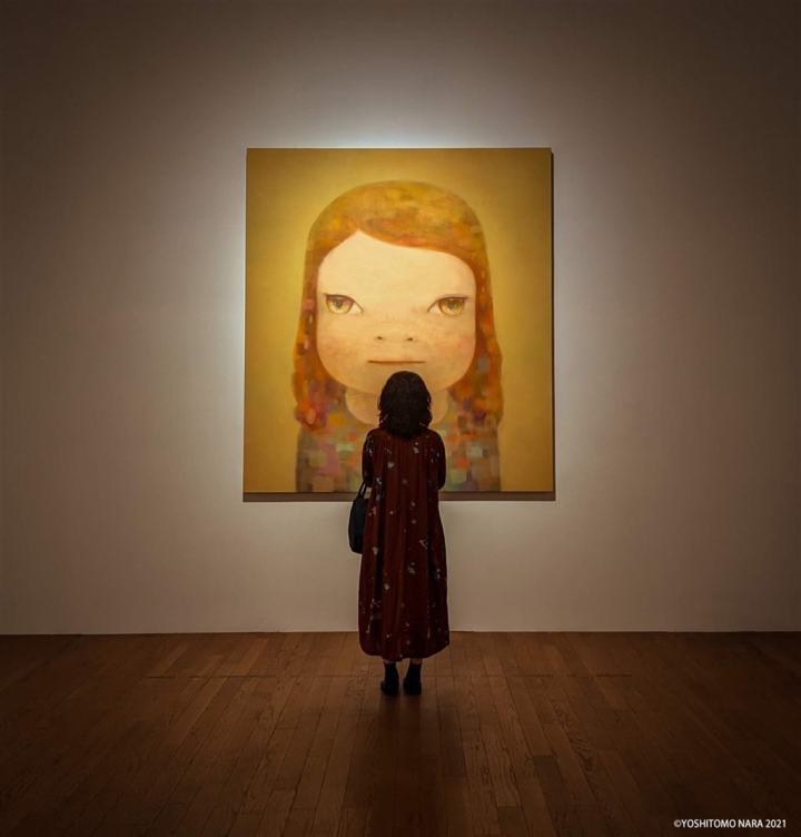 A woman stands in front of Japanese artist Yoshitomo Nara's "Hazy Humid Day" when it was on display in Tainan in November 2021.