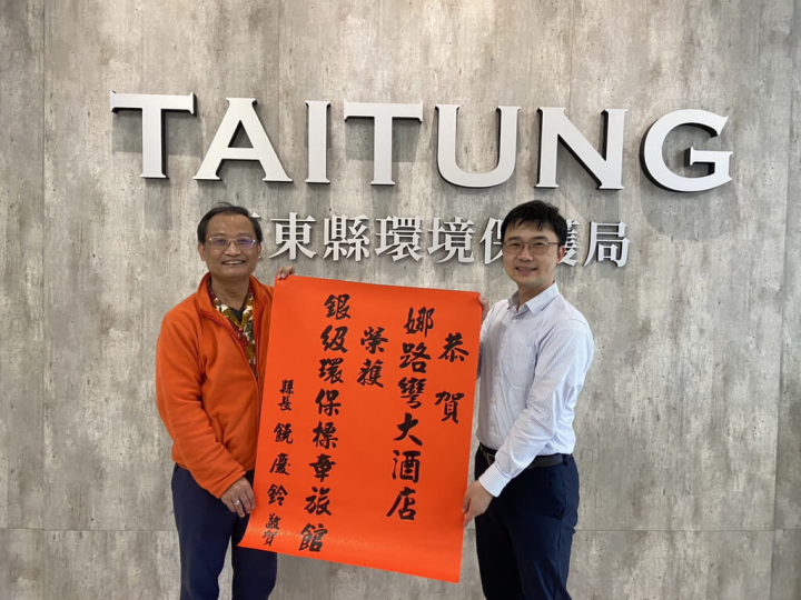 台東低碳旅遊創下里程碑，經台東縣環境保護局輔導，娜路彎大酒店獲行政院環保署肯定，台東縣環保局長郭建成（右）頒發紅榜恭賀，娜路彎副總林明政（左）代表受獎。（台東縣政府提供）