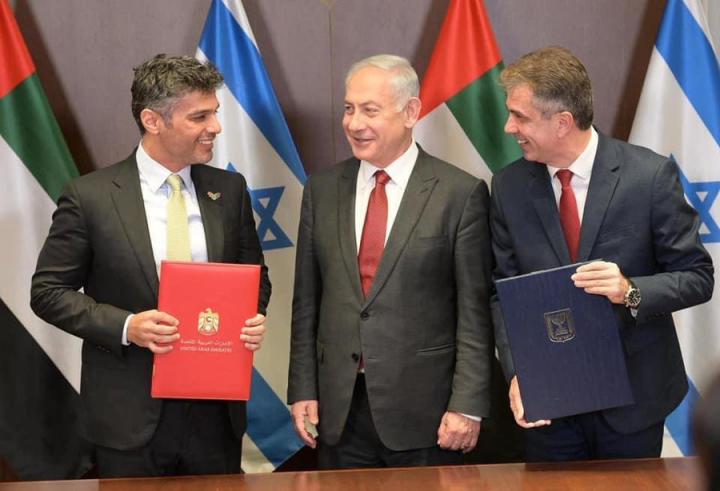 在以色列總理尼坦雅胡(中) 見證下，以色列外長柯恩(Eli Cohen)( 右)和阿聯駐以色列大使哈賈(Mohamed Al Khaja)(左)簽署兩國關稅協議。(推特) 