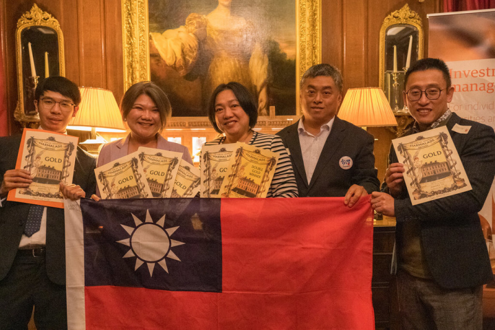 台灣品牌參加英國「世界柑橘類果醬大賽」締造史上最佳成績，共奪21個大獎，得獎人林韡勳（左1）、柯亞（左2）、郭恩綺（左3）、三福果富副總王柏鈞（右1）與國旗合影。（三福果富／Ning yuhsiang提供）