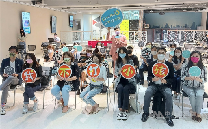 Attendees hold signs saying "I don't hit children" at a Humanistic Education Foundation news conference on April 27, 2022 to mark April 30 International Day to End Corporal Punishment of Children.
