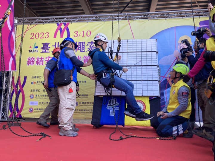 台北市長蔣萬安（前左2）10日體驗使用繩索進行外牆檢修作業，表示將努力確保勞工的安全工作環境。