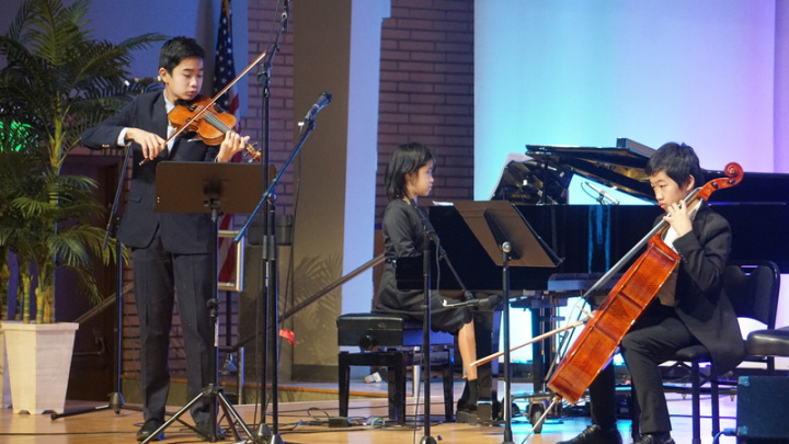 15歲的小提琴手楊宸睿（Gavin Yang）（左）和雙胞胎弟妹楊峮寧（Ivalyn Yang）（中）、楊峮睿（Ivarett Yang）組成三重奏，在「台灣介心靈日」228紀念音樂會上演出。