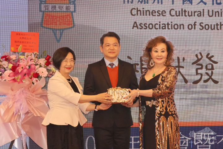 在紀欽耀見證下，滿任會長車慶餘(左)與新任會長陳萍如(右)完成交接