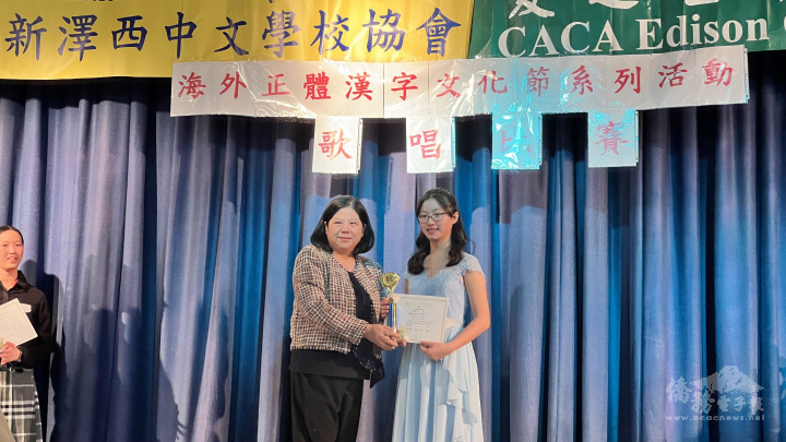 江海寧(左)頒獎給高年級第一名愛迪生中文學校梁煜惠(右)