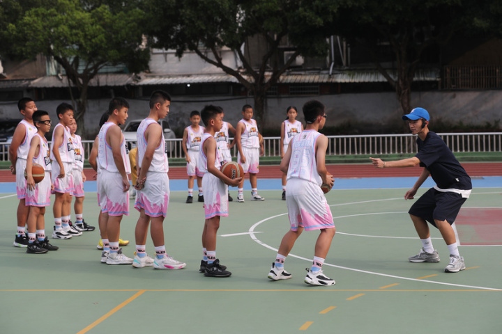 武林國小籃球隊教練鍾育庭（右）自創一套與小球員的互動模式，以略帶揶揄、詼諧的方式指導，不但少了怒罵的情緒字眼，也讓小球員們心情不會太緊繃。