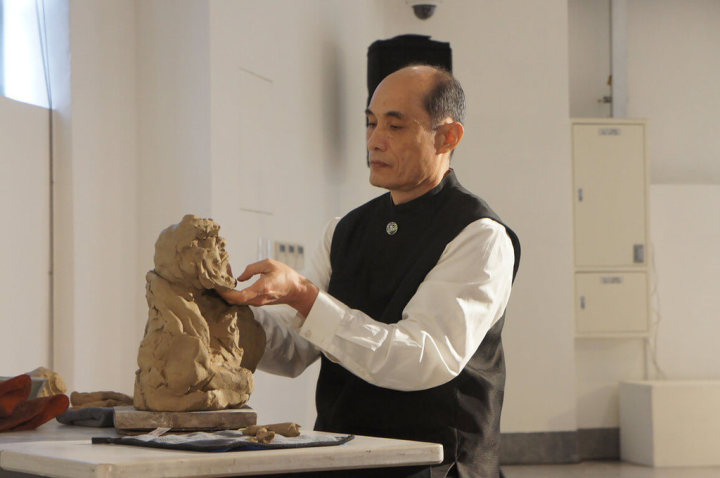 台灣工藝研究發展中心在台北當代工藝設計分館舉辦「自然．至燃－筆墨云硘 林文嶽創作展」，呈現陶藝師林文嶽如何以水墨畫結合柴燒、青瓷、泥塑等創作。圖為林文嶽示範手捏「達摩」系列作品。（工藝中心提供）