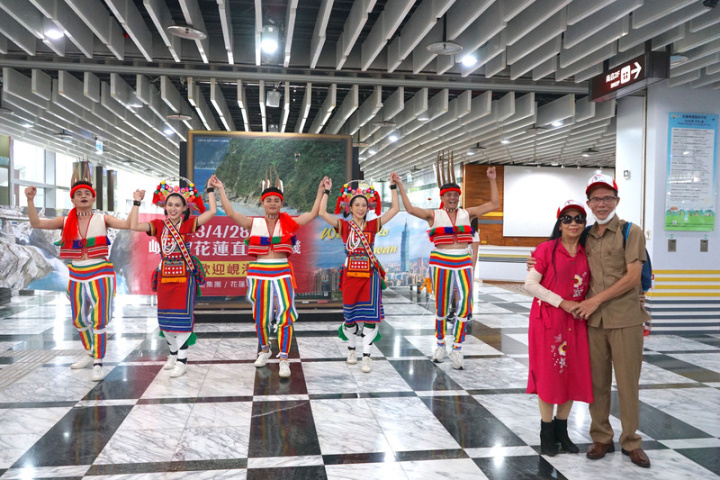 花蓮航空站28日下午迎來解封後首架國際航班，除航空站準備噴水儀式歡迎外，花蓮縣府也在機場安排原民舞團、觀光志工列隊迎接，遊客們也開心與舞者合影。