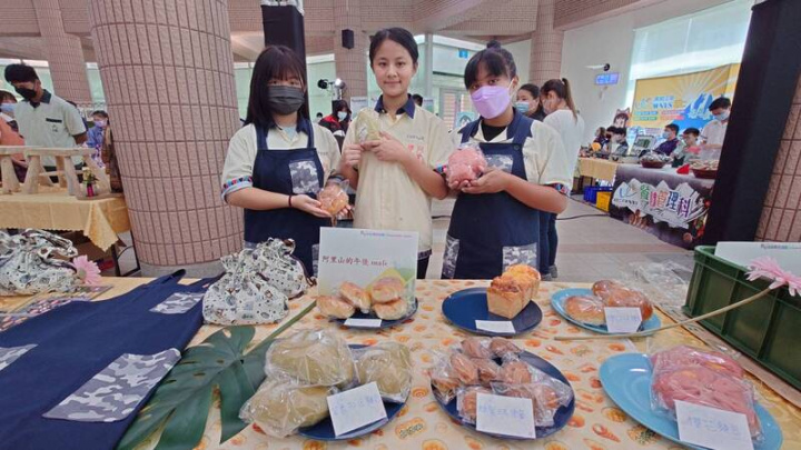 嘉義縣28日舉辦國中技藝教育學程競賽頒獎典禮暨成果發表會，阿里山國中小學鄒族學生汪莘芸（前右）從山上帶來親手烘培的茶香紅豆麵包、櫻花麵包等，吃過的都說讚。