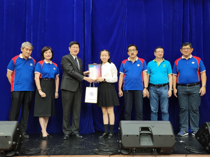 梁崇偉〈左3〉、吳治平〈右3〉、陳柏材〈右2〉、黃仲廷〈右1〉及梁俊如〈左2〉等人頒發獎金、獎狀予學生現場華文作文比賽優勝者