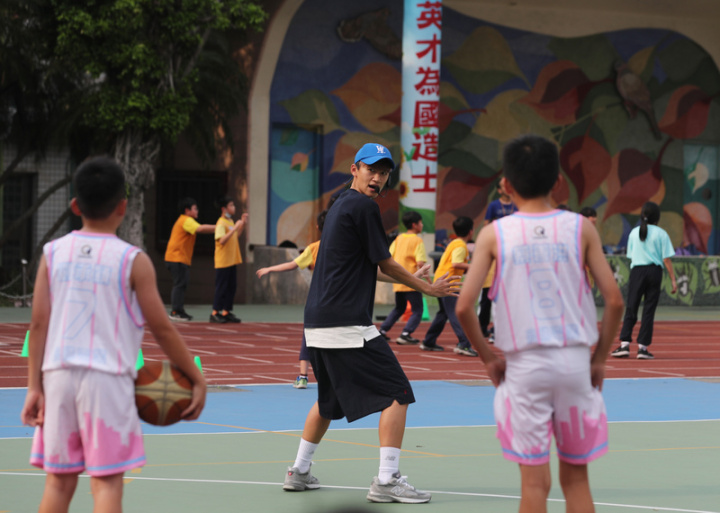 現年36歲的武林國小籃球隊教練鍾育庭（中）常會親自下場示範，並自創一套和小球員的溝通方式，利用開玩笑般的幽默風格，讓球員當下就知道錯在哪裡。