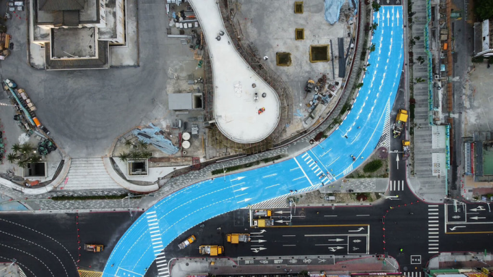 高雄市工務局8日晚間加速進行高雄車站周邊中山、建國、站東路口車道彩色鋪面工程，9日上午7時提前完工並開放通行，夜間不再施工。圖為從空中俯瞰完工的站東路彩色鋪面。（高雄市政府工務局提供）