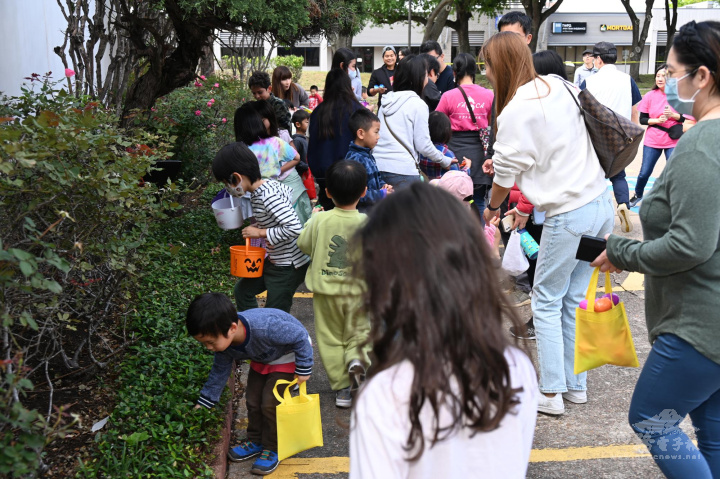 年輕世代父母陪著子女在文教中心前廣場尋找彩蛋