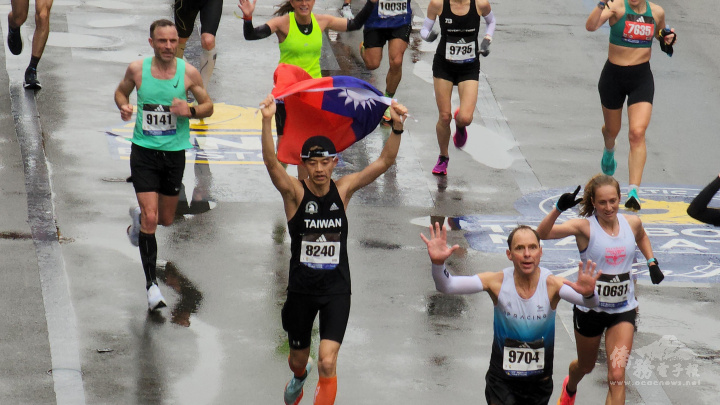 住在台中的Yu, Hung Chih高舉國旗跑過馬拉松終點線。