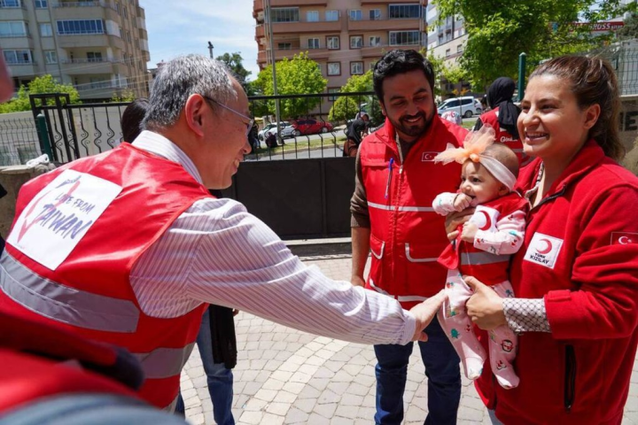 駐土耳其代表黃志揚（前排左）5月4日赴震央卡拉曼馬拉斯省，視察與非政府組織紅新月會合作援助災民的計畫執行情形。穿紅新月會志工背心的嬰兒於震災前3天出生，被視為「災區的希望」。（駐土耳其代表處提供）