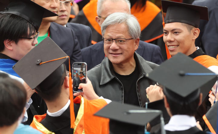 國立台灣大學27日舉辦畢業典禮，邀請身價逾新台幣1兆元、有「AI教父」之稱的的輝達（NVIDIA）執行長黃仁勳（中）出席致詞，黃仁勳抵達現場時，許多學生紛紛上前與黃仁勳合影。