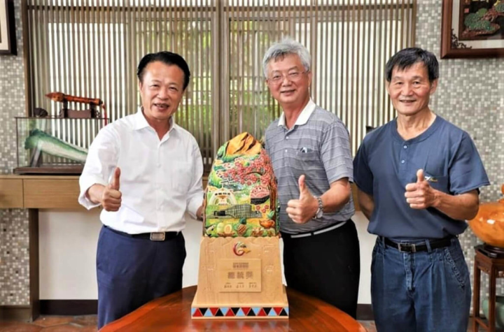工藝家謝東哲（中）為嘉義縣創作特殊的交趾陶獎座，展現嘉義文化特色。圖為111年全民運動會團體獎座，縣長翁章梁（左）、謝東哲及獎座合影。（謝東哲提供）