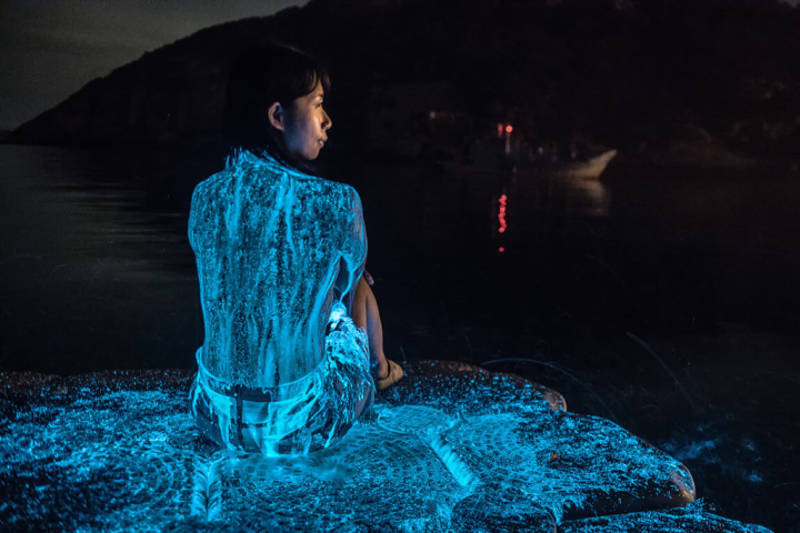 馬祖近日藍眼淚大量爆發，北竿追淚達人周治孝更拍到遊客身體披上藍光畫面，他說，這張照片沒有修圖，是藉潑海水在遊客身上而拍出的效果。（「馬祖有個周小馬 追淚人」提供）