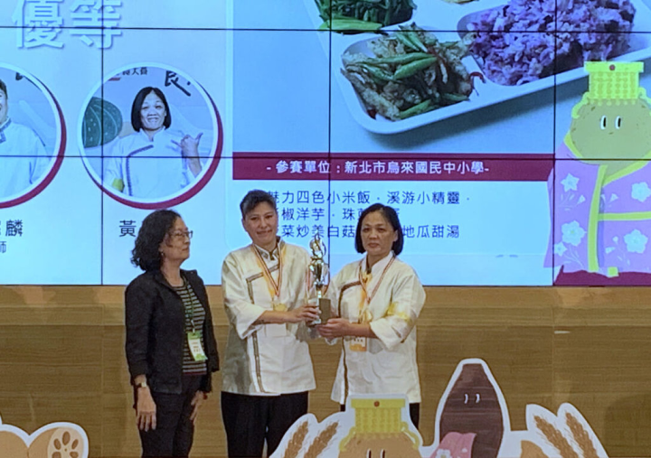 新北市烏來國民中小學廚師李懿麟（中）、黃彩鳳（右）精心設計學生午餐，除採全穀類食材外，菜色包含魅力四色小米飯、溪游小精靈、彩椒洋芋、珠蔥烘蛋、菠菜炒美白菇及芳香地瓜湯，日前獲第6屆台灣學校午餐大賽發表組優等表揚。（新北市教育局提供）