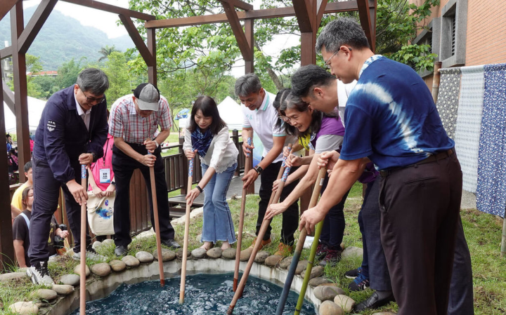 112年新北藍茶藝術季20日在新北市客家文化園區舉行，現場活動多元，包含「打藍」體驗，參與民眾齊聚菁礐池邊體驗「打藍」過程。（新北市客家局提供）