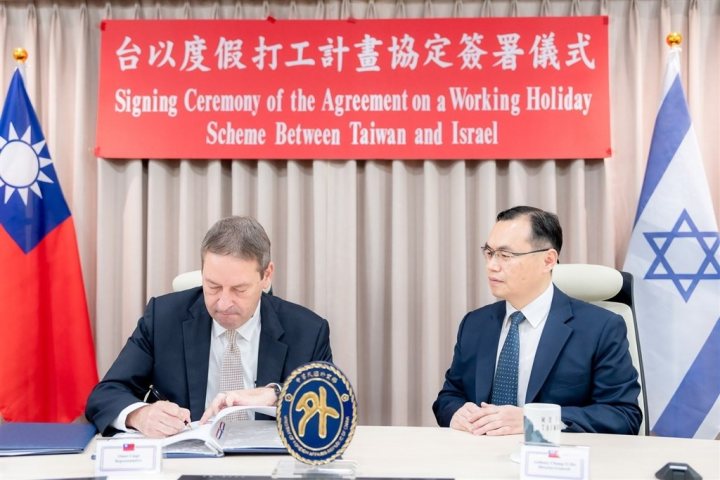 Israeli representative to Taiwan, Omer Caspi (left), signs the working holiday agreement in Taipei Wednesday, with Anthony Ho, head of MOFA's Department of West Asian and African Affairs, serving as a witness in this press photo released by the foreign ministry.