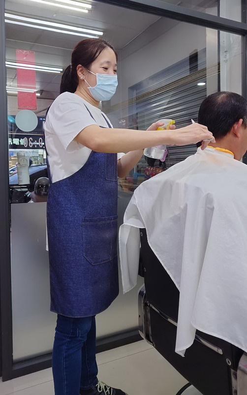 滿20歲就嫁來台灣的單親越南新住民陶玥菱（左），原以打零工養活2個孩子，在親朋好友協助下習得一技之長，在嘉義市開設男士理髮店，行有餘力義剪助人。
