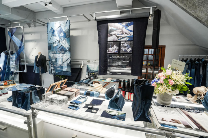 主打永續時尚的台灣服裝品牌Story Wear將昔日台北大稻埕的紡織廠轉化為永續文化基地，並利用淘汰牛仔布作為裝飾，將3捲牛仔布吊掛在牆面上，透過廢棄布料說故事。（Story Wear提供）