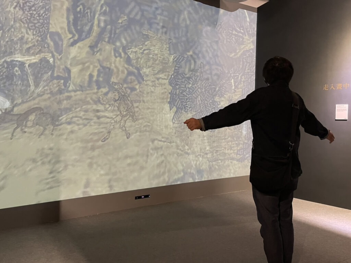 故宮博物院與台北松山奉天宮合作推出數位展覽「跟著皇帝去旅行－故宮錫口遊」，其中體感互動裝置「走入畫中」，可讓民眾化為飛鳥，飛入北宋畫家范寬的「谿山行旅圖」中。（故宮提供）