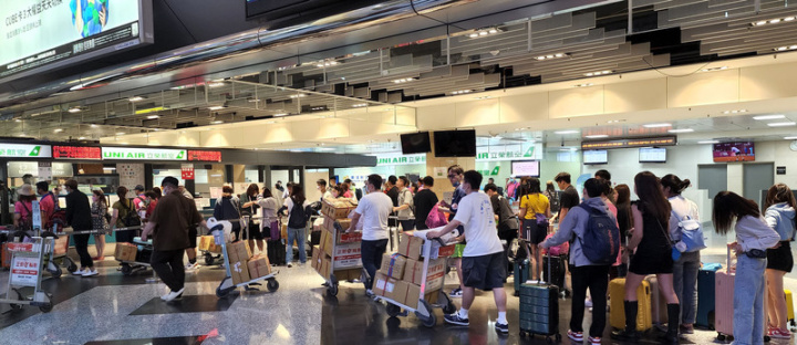 端午連假25日將落幕，馬公航空站表示，澎湖機場各航線本日共起降57架次、提供6565機位，除少數航班有零星空位外，幾乎班班客滿。圖為機場服務櫃台前許多民眾帶著大包小包的行李排隊等待辦理相關手續。