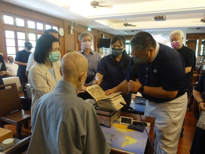 Muslim Tzu Chi volunteer Faisal Hu (right) and the team from the National Taiwan Library who complete the restoration of a handwritten copy of the Quran present the restored Quran to Master Cheng Yen. (Photo courtesy of Buddhist Tzu Chi Charity Foundation)
