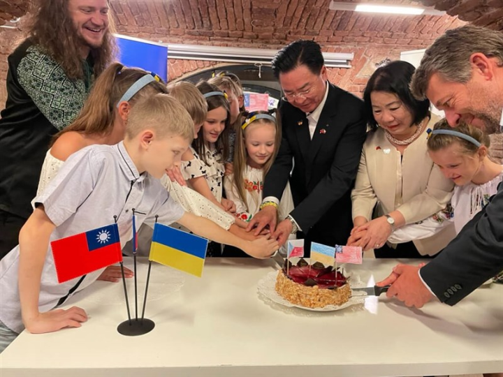 Foreign Minister Joseph Wu cuts a cake with Ukrainian children in the People in Need headquarters on Wednesday in Prague. Photo courtesy of Ministry of Foreign Affairs June 15, 2023