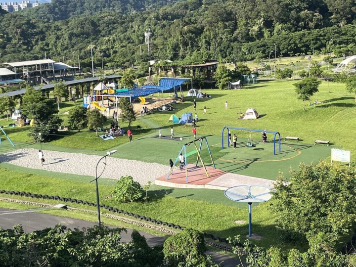 台北市南港山水綠生態公園不僅場域寬廣且有大片綠油油草地，園區內還有兒童及共融式遊樂設施、遮陽玩沙區，適合親子同遊。（環保局提供）