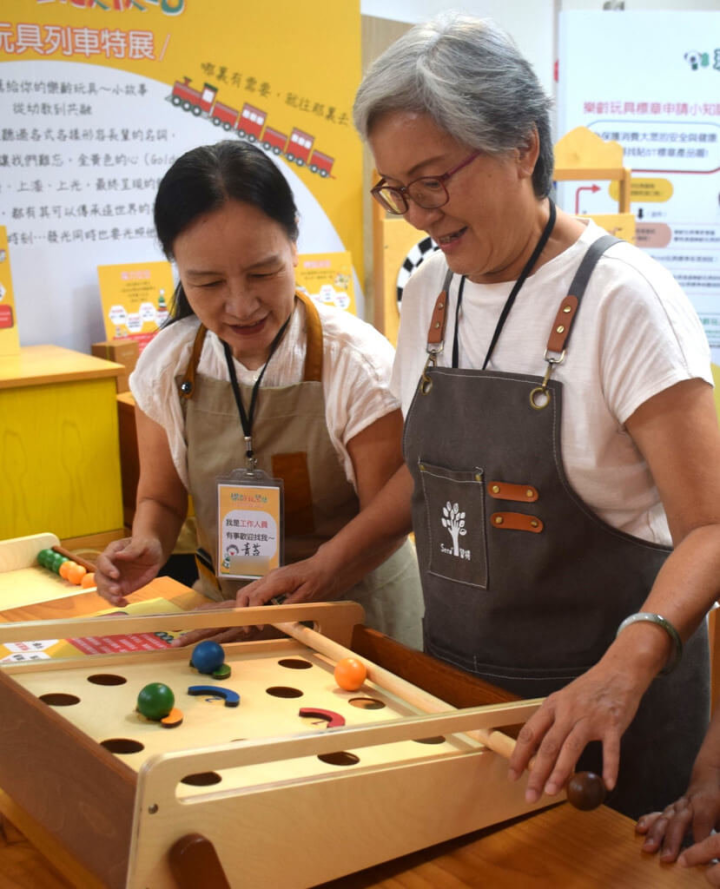 台北龍山文創基地「樂齡玩聚站」29日開幕，自貿易業退休的Tiffany（右）擔任導覽，她表示，經基督教芥菜種會協助溝通，設計出1週3天、每次4小時的導覽工作，讓62歲的她不會有太大體力負荷，也有機會與年輕世代合作，互相學習。（芥菜種會提供）