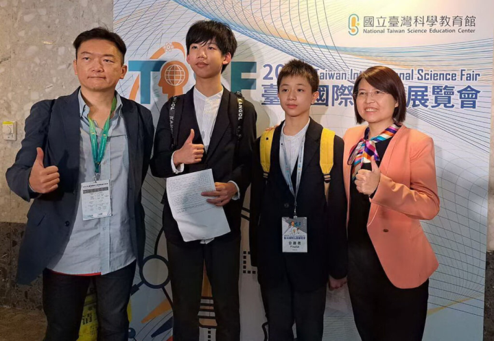新北市崇林國中學生王淮誱（左2）、賴守義（右2）研究幹細胞投入抗癌應用，並參加2023年國際科展，雖未得獎但獲高度評價，兩人與指導老師羅陽青（左）、校長徐巧玲（右）開心合影。（崇林國中提供）