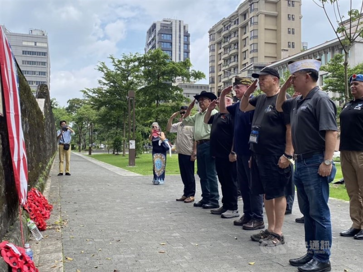 Members of Taiwan POW Camps Memorial Society, Taiwan's Cabinet-level Veterans Affairs Council, the Flying Tigers Post 9957 and other attendees salute the memorial plaque of 14 fallen U.S. airmen Sunday. CNA photo June 18, 2023