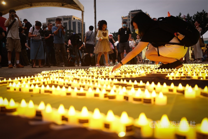 Attendees of the annual vigil to remember a violent crackdown on pro-democracy protesters by Chinese authorities in Beijing 34 years ago on June 4 place candles in front of the Chiang Kai-shek Memorial Hall Sunday. 