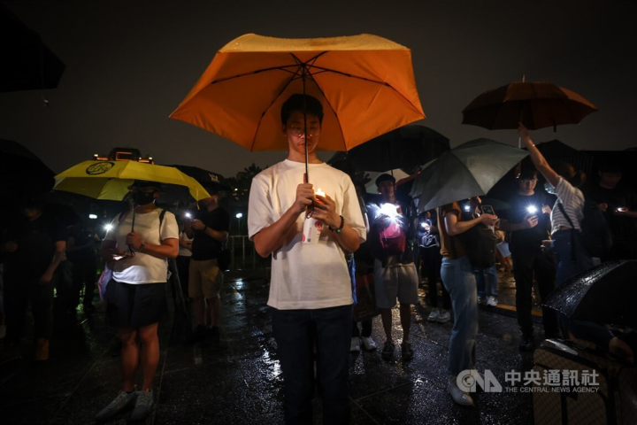 People taking part in the vigil in the rain in Taipei Sunday evening. 