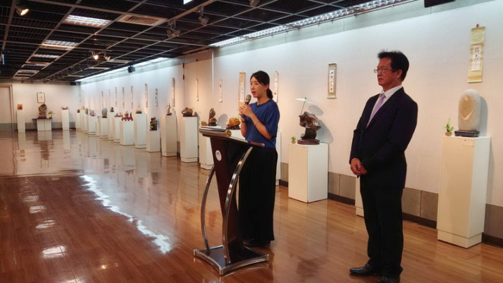 嘉義市愛石會7日在市府文化局舉辦成果展，展出上百件雅石與石雕，嘉義市立美術館館長賴依欣（左）出席開幕活動致詞表示，自古文人雅士即愛收藏雅石，現場看到各種奇石令人大開眼界。