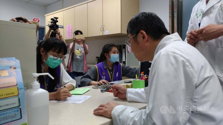 A health worker (in purple vest) at National Taiwan University Hospital Yunlin Branch speaks with then Superintendent Jen Hwang (sitting, in white) to demonstrate a cancer consultation for the press in this photo taken on April 25, 2018. CNA photo