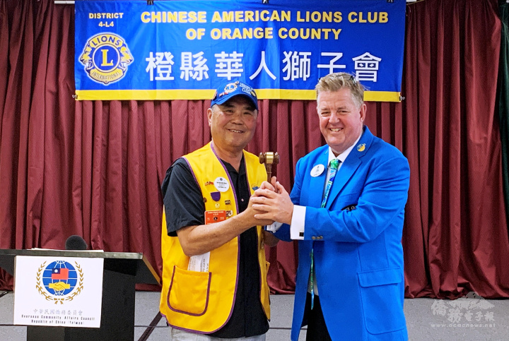 國際獅子會District 4-L4區長克雷格‧杜蘭特(Craig J Durand，右)將獅子會開會敲鐘槌，授予橙縣華人獅子會現任會長洪陳鋒(左)