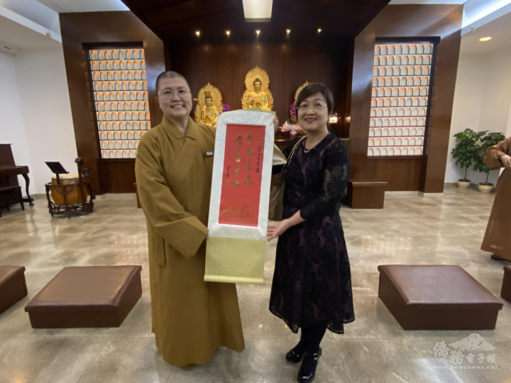 如來寺住持妙佑法師（左）贈送星雲大師墨寶掛軸給徐佳青（右）