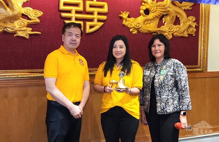 麻州第33K區候任會長Ivette Mesmar(右起)主禮，卸任會長李典儒(左)把議事槌和金鐘交給新任會長周麗玲